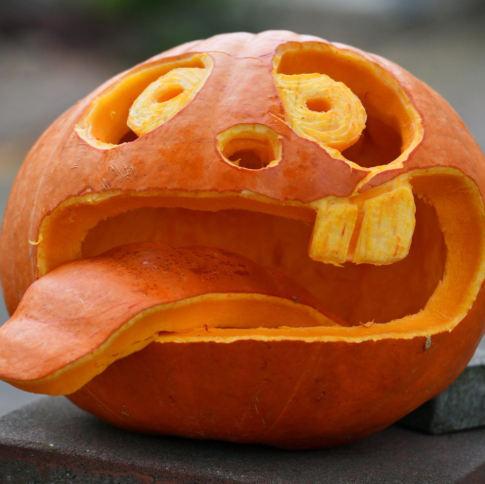 An amusing pumpkin carving of a toothless face sticking out its tongue.